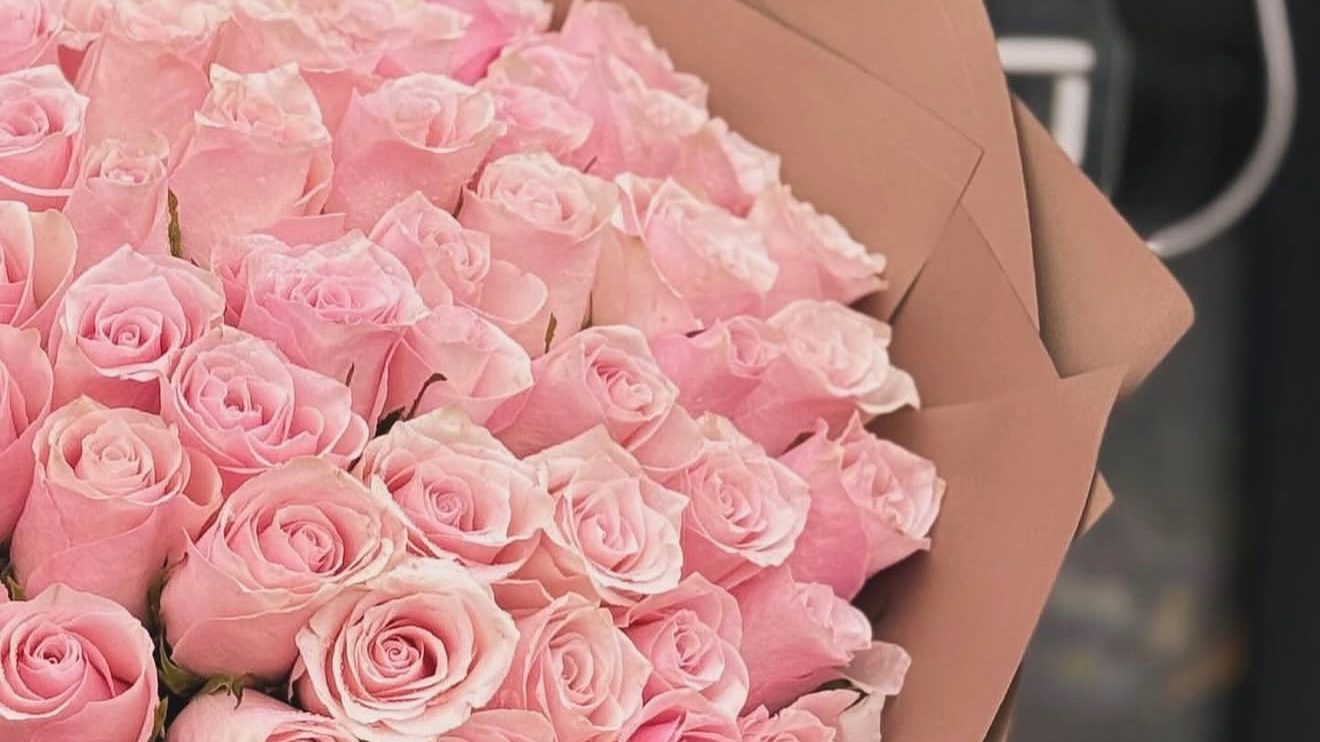 Pink rose bouquet in brown wrap outside the Flowers YEG shop in Edmonton